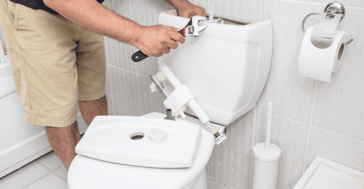 man repairing running toilet