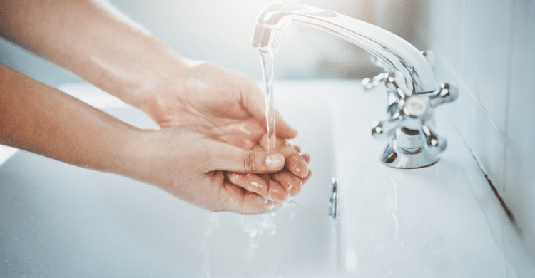 person washing hands under running water