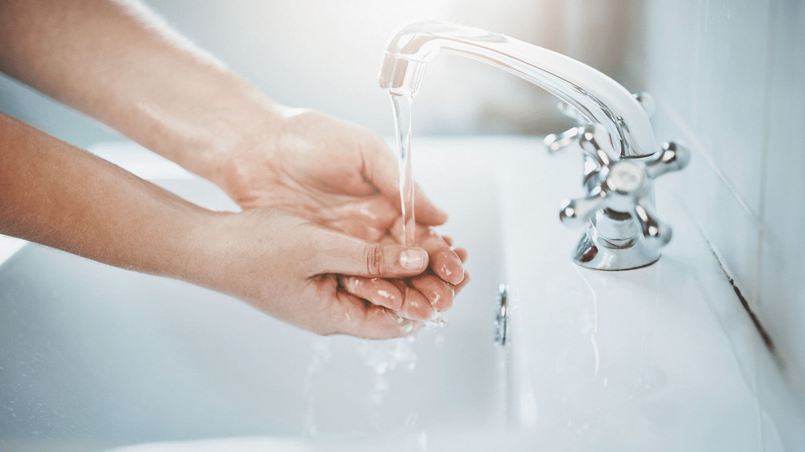 person washing hands under running water