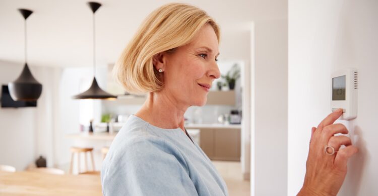 woman turning off AC system in home