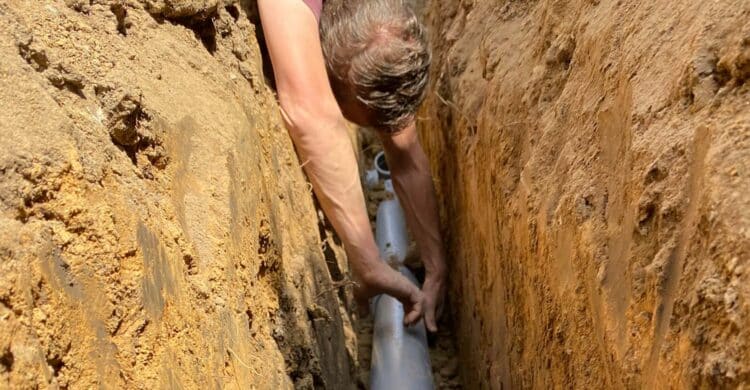 man installs sewage drain