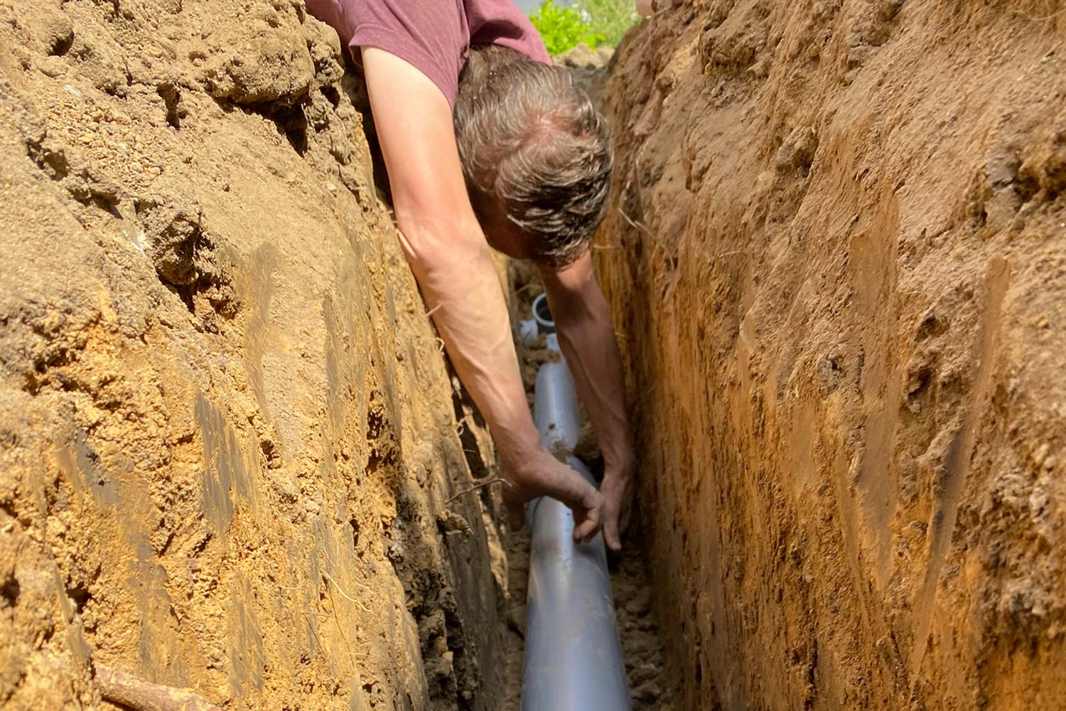 man installs sewage drain